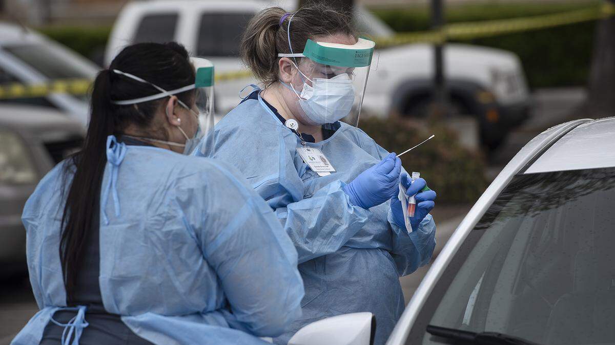 Nurse practitioner Danielle Groce administers a COVID-19 test at a Golden Valley Health Center test station in Ceres, Calif., on Wednesday, March 25, 2020. Medical assistant Maria Aragon, left, helps with translation. GVHC have two drive-thru viral testing sites, one in Ceres and one in Merced, but these are available only for GVHC clients from 9 a.m. to 3 p.m. with a referral from their provider.
