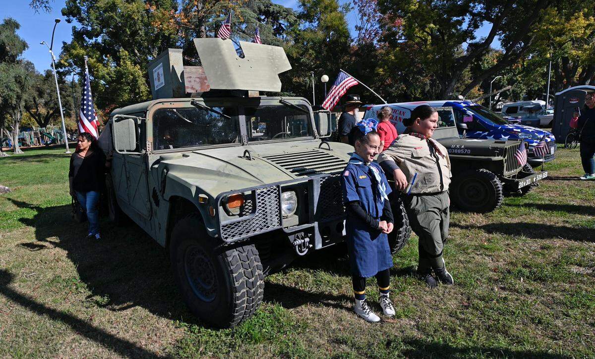 Nola Peitz, 8, and her brother Nickolai, 10, pose for pictures during the Veterans Day event at Graceada Park in Modesto, Calif., Saturday, Nov. 11, 2023.