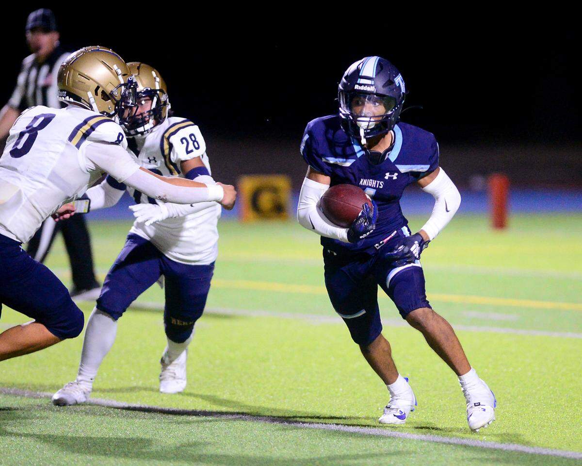 Downey running back Julius Padron (1) cuts away from two defenders during a game between Downey High School and Elk Grove High School at Downey High School in Modesto, Calif. on August 30, 2024.