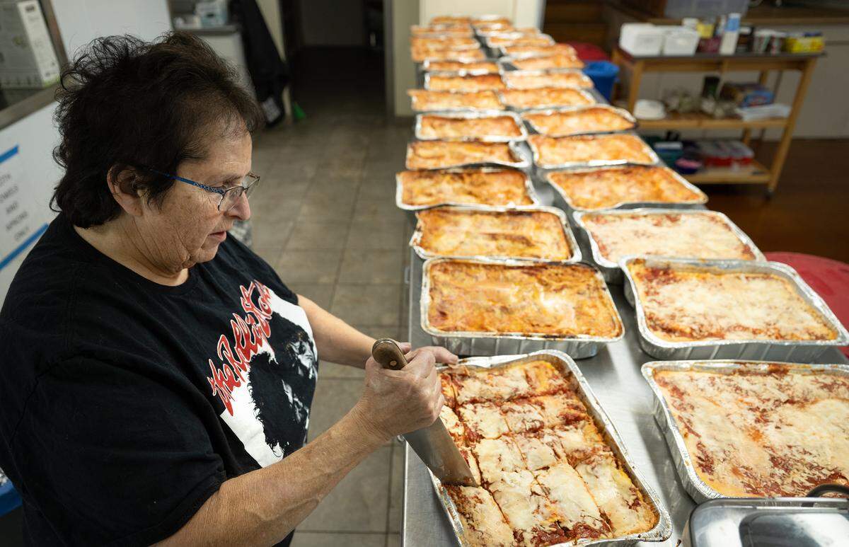 Joyce Gandelman slices lasagna as she and other volunteers prepare a holiday meal for first responders at Congregation Beth Shalom synagogue in Modesto, Tuesday, Dec. 24, 2024. Members of the congregation plan to deliver 250 and 300 meals, which include lasagna, salad, garlic bread and desserts, to area first responders Christmas Eve night.
