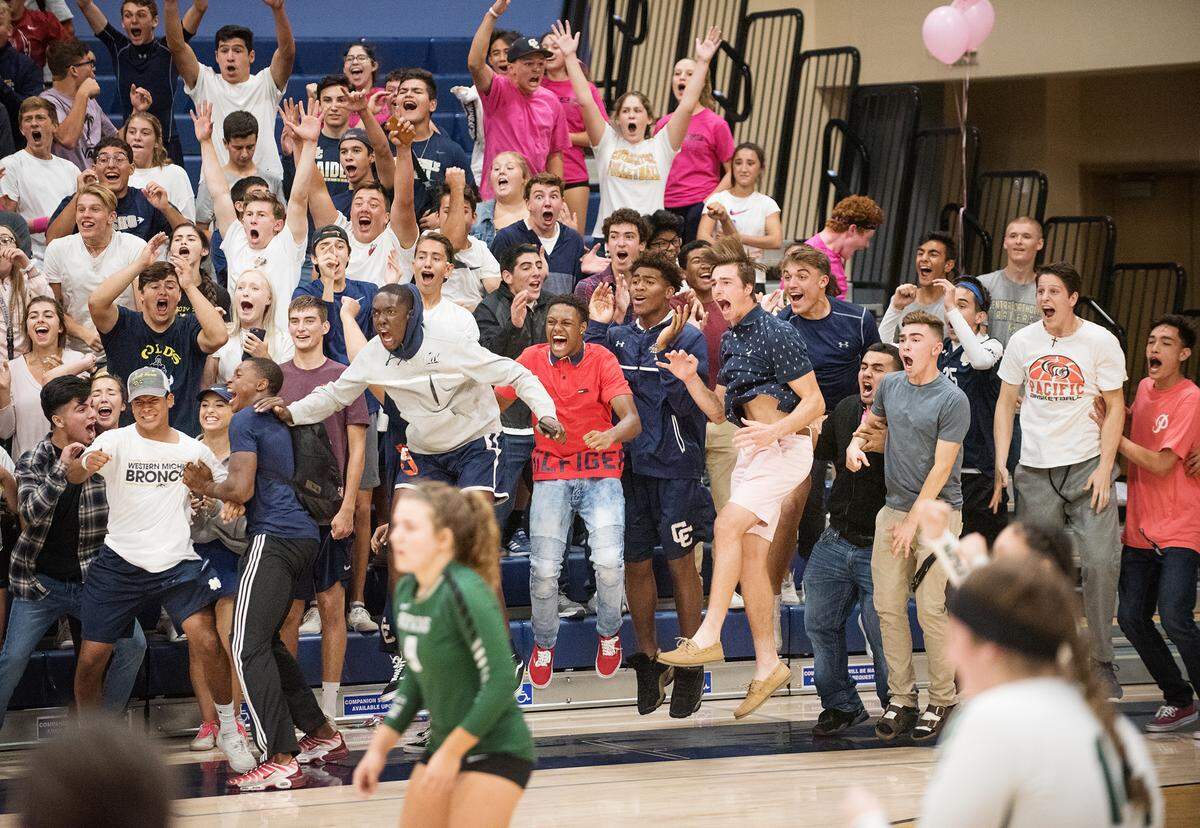 Central Catholic student section erupts after the Raiders win a long rally during the Valley Oak League match with Manteca at Central Catholic High School in Modesto, Calif., on Thursday, Oct. 4, 2018.