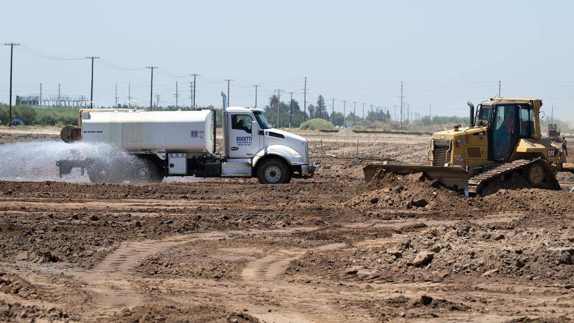 A water truck wets down the soil as workers prepare the site of the new Costco in Riverbank, Calif., Wednesday, August 9, 2023.