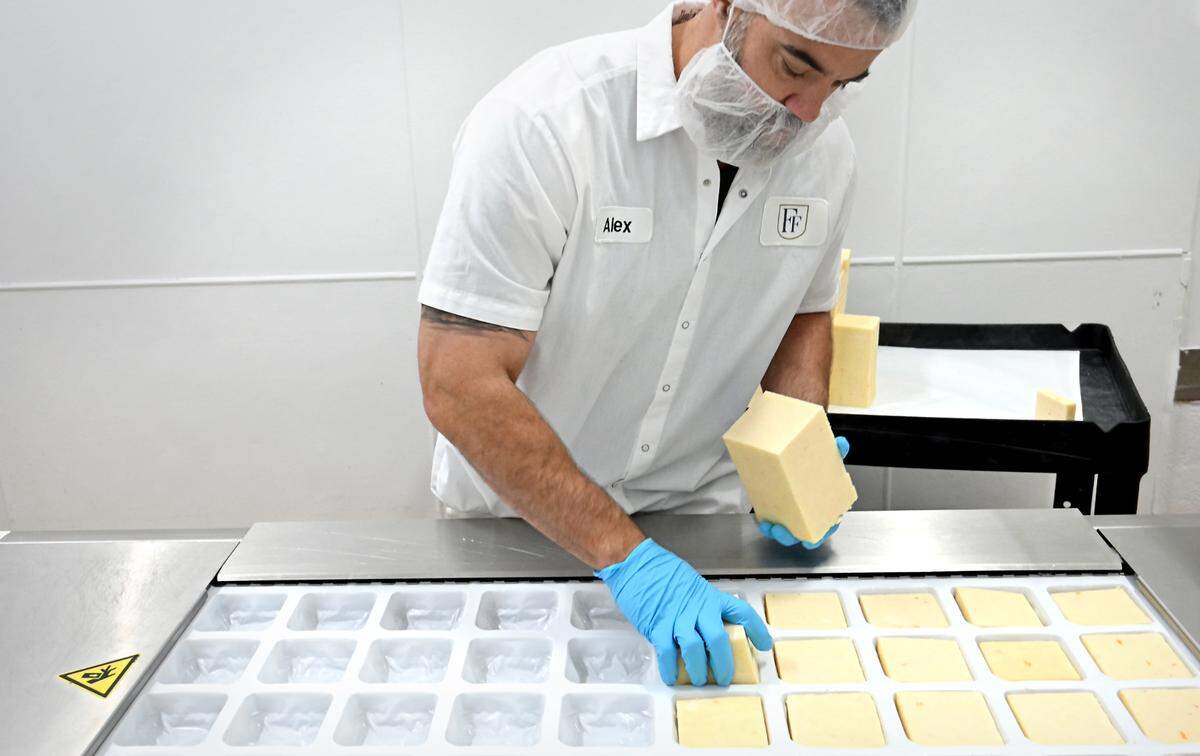 Operations manager Alex Borgo demonstrates the cheese packaging machine at Fiscalini Farmstead in Modesto, Calif., Wednesday, April 10, 2024.