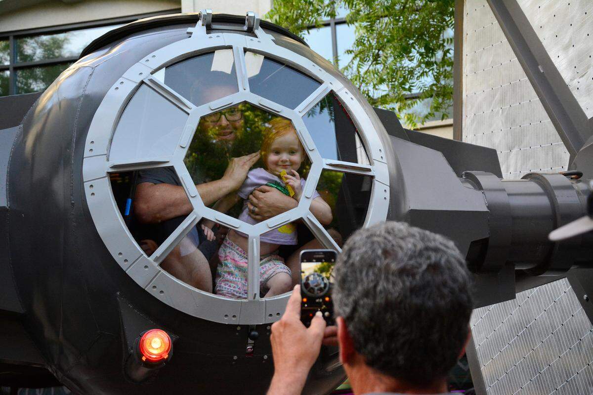 May The Fourth Star Wars Day brought out hundreds to Tenth Street Place May 4, 2018 in Modesto, Calif. The free public event included Star Wars cosplayers, live music and a performance by the Beyer High band. Pictured Sam Stephens of Modesto and his daughter Eleanor, 3, pose inside of a custom-built TIE-fighter.