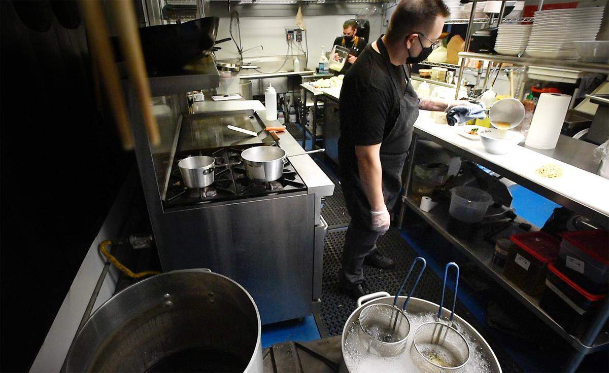 Owner and chef Ernie Watkins prepares a bowl of ramen at Konfucious Eats in McHenry Village in Modesto, Calif., on Thursday, Feb. 4, 2021.