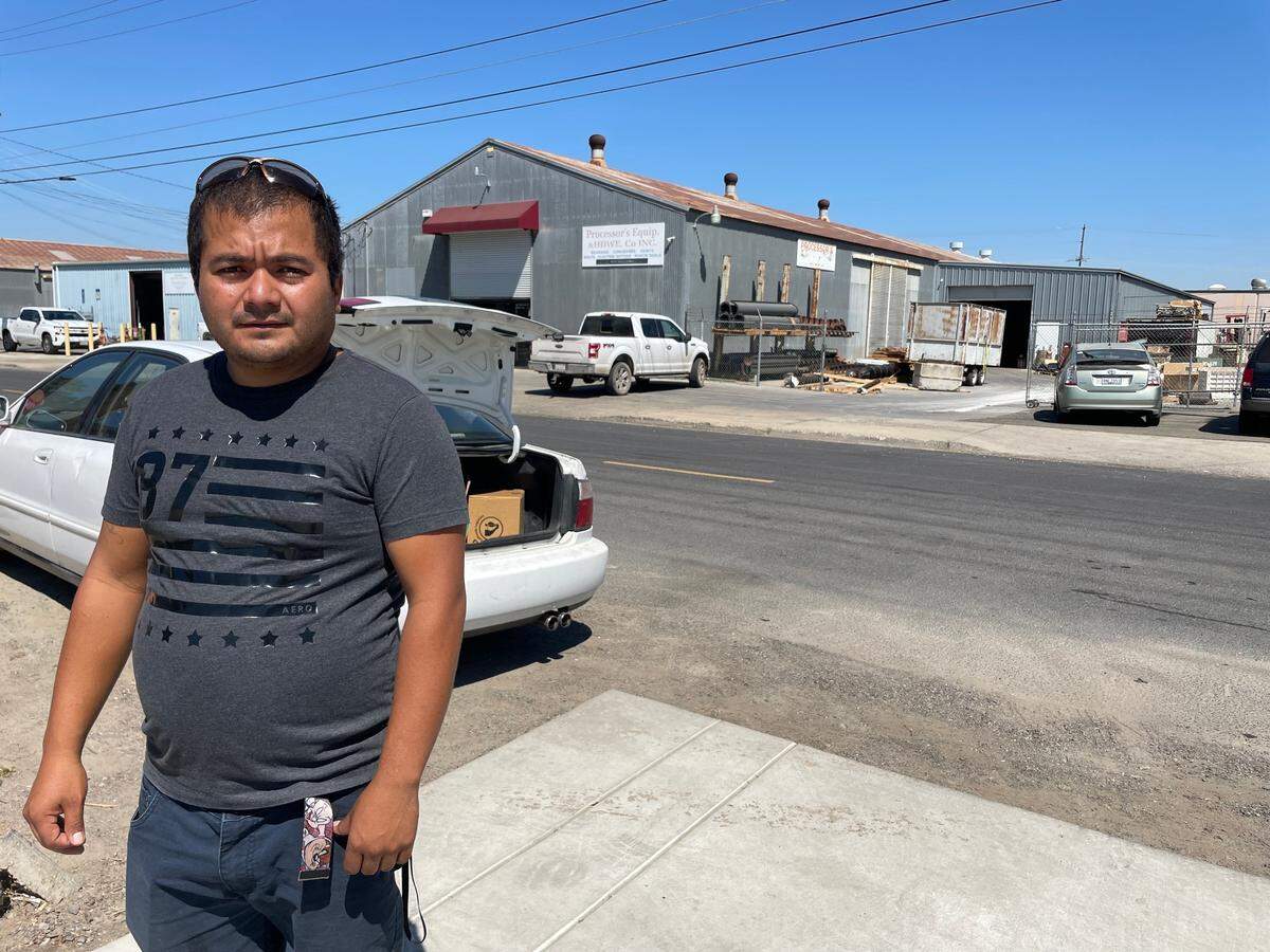 Jose Villalobo Mendoza, 34, stands in the parking lot of the Rock Church, where his family is receiving food assistance.