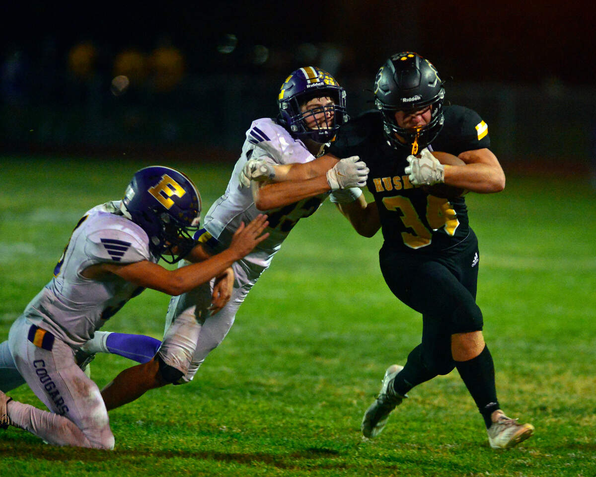 Hughson running back Will Nutcher slips past two Escalon defenders during a football game between Hughson High School and Escalon High School at Hughson High School in Hughson California on September 17, 2021
