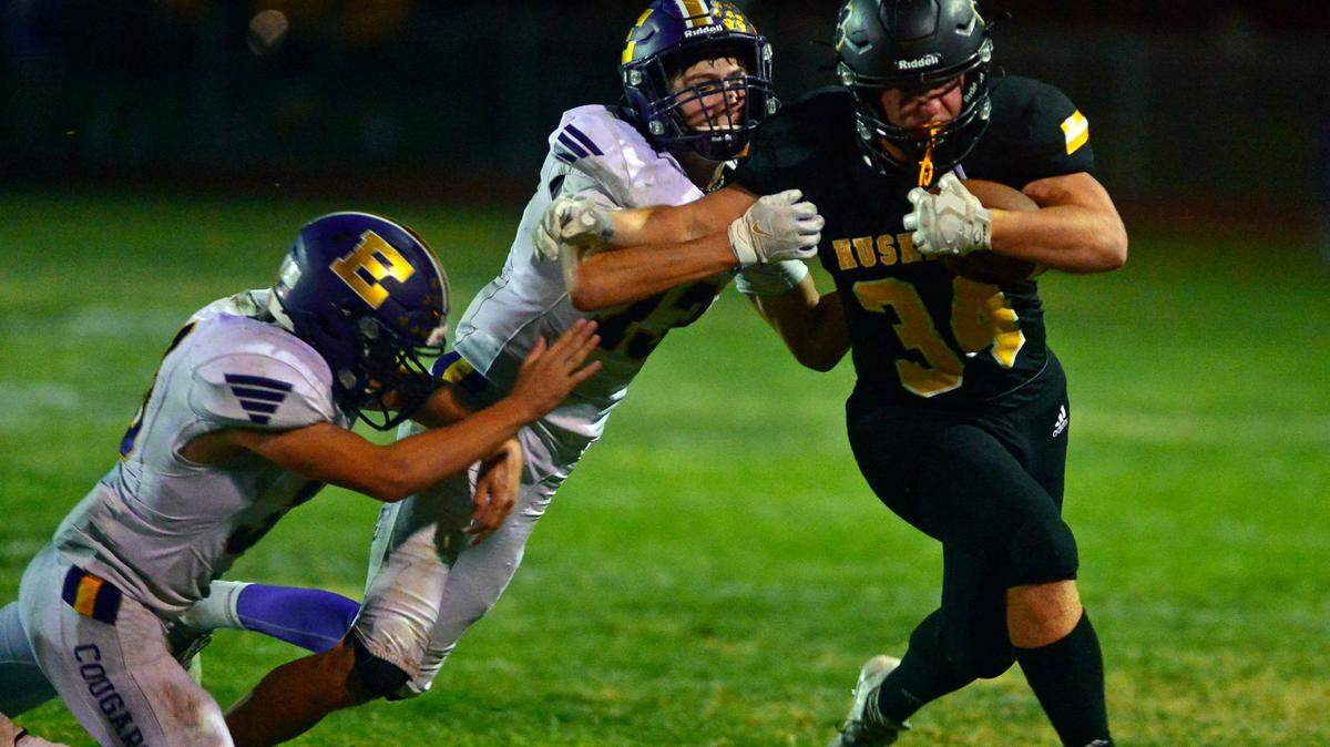 Hughson running back Will Nutcher slips past two Escalon defenders during a football game between Hughson High School and Escalon High School at Hughson High School in Hughson California on September 17, 2021