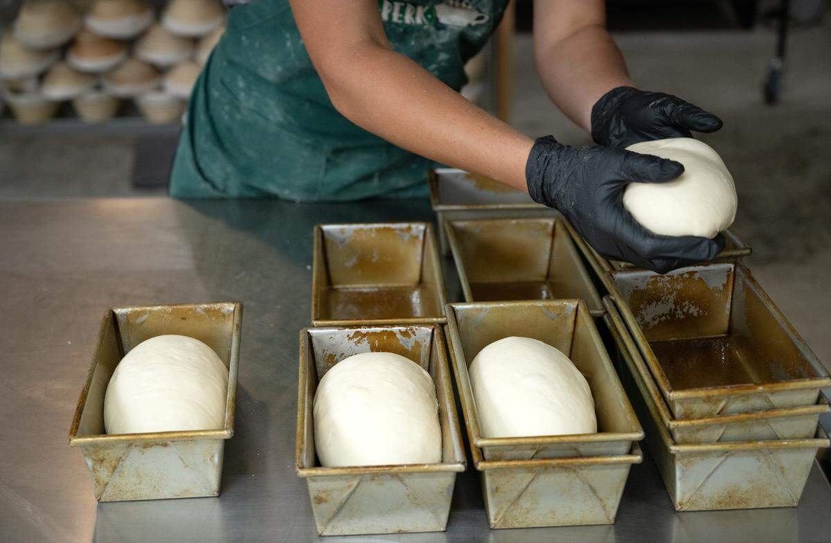 Emily Melgard forms dough for loaf bread at MatKat Sourdough bakery in Oakdale, Calif., Wednesday, July 24, 2024.