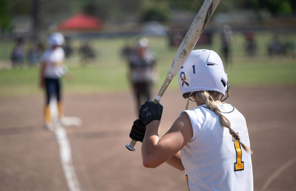 Turlock’s Natalie Sahlstrom awaits a pitch from Pitman pitcher Gabby Pacheco during the Central California Athletic League game at Turlock High School in Turlock, Calif., on Thursday, April 7, 2022. Players from Turlock High joined Kayleen Zayehmoureh in wearing blue ribbons with Carlos Perales’ initials on their batting helmets to remember Kayleen’s father who died recently.