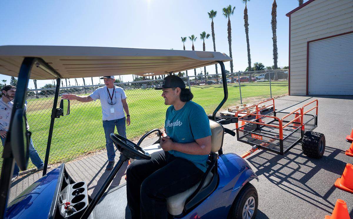 Teacher David Dein talks with trucking student Andres Lopez, seated, during a trailer backing exercise at Patterson High School in Patterson, Calif., Friday, Oct. 27, 2023.