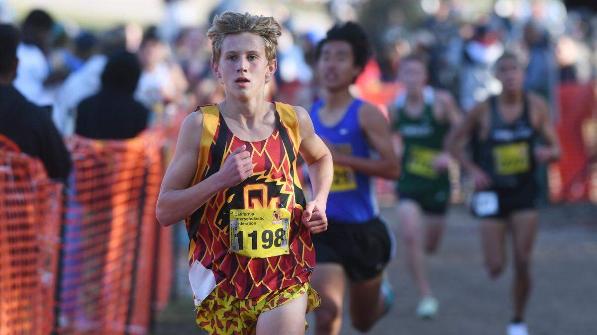 Oakdale’s Caleb Cavanaugh, left, who placed 12th, seen in the Boys Division III race at the CIF state cross country championships held at Woodward Park Saturday, Nov. 27, 2021 in Fresno.