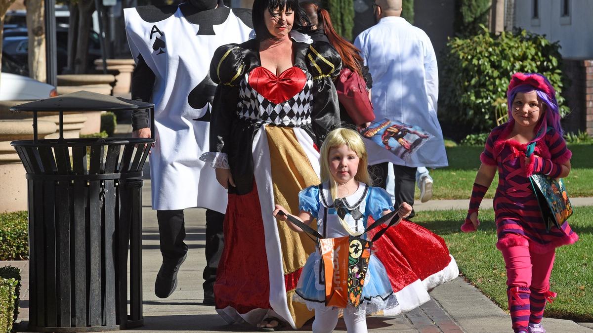 The Brown family from left to right- Nick, Crystal, Tessa 4yrs and Roxy 7yrs (far right) wear Alice In Wonderland costumes walking down Main street Tuesday afternoon October 30, 2018 as they take part in Downtown Ripon’s Trick-or-Treat.