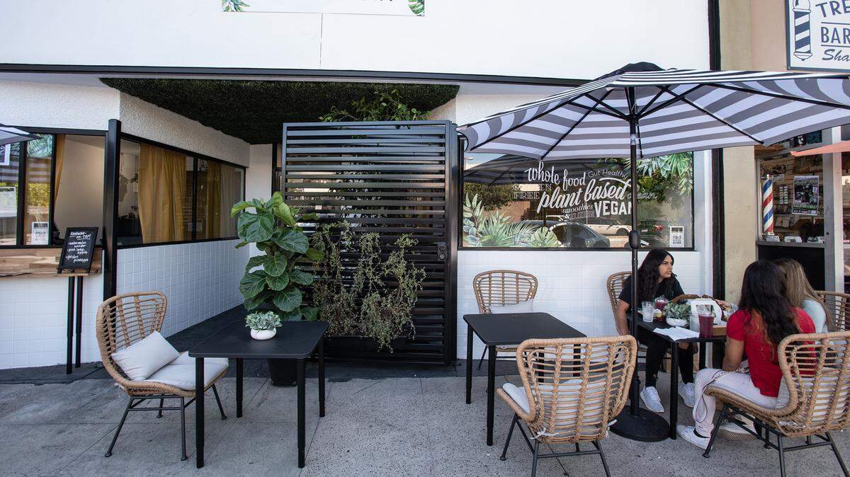 Sisters Melisa Alcaraz and Joana Alcaraz, right, eat lunch with friend Alicia Rubio at the Farmacy restaruant on 10th Street in Modesto, Calif., on Thursday, July 8, 2021.