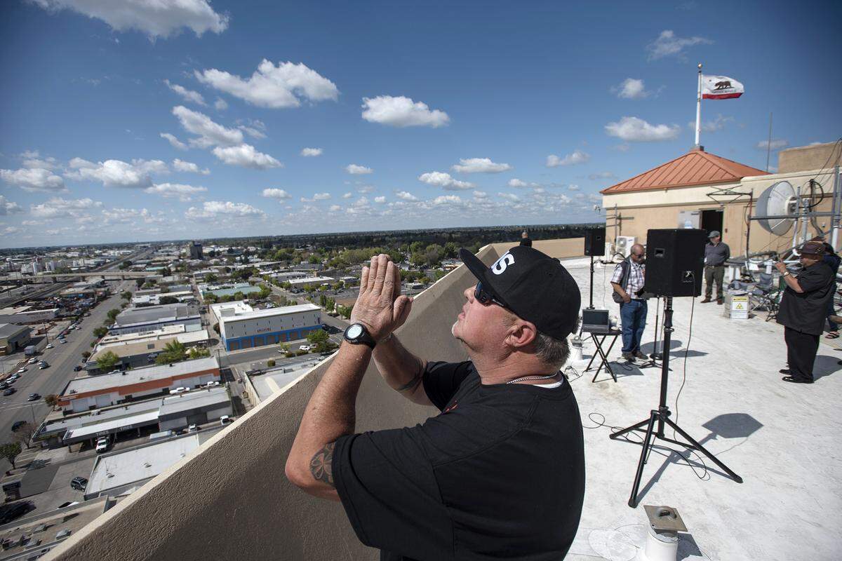 Justin Downs prays with other Modesto-area church members who gathered on the roof of the 15-story DoubleTree Hotel in Modesto, California, to pray over the city and for people affected by coronavirus in Modesto, Calif., on Tuesday, April 7, 2020.