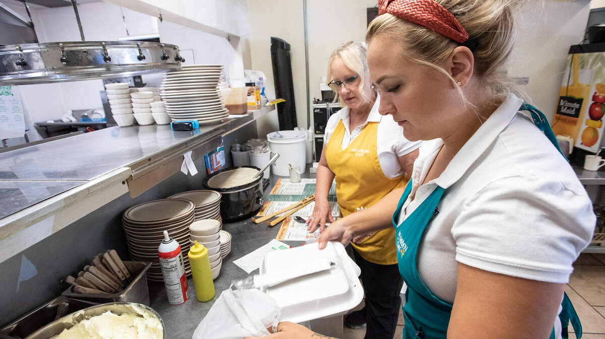Cheyanne LoBue, right, and Shelia Wooley prepare food delivery orders at My Garden Cafe in Modesto, Calif., on Friday, May 13, 2022.
