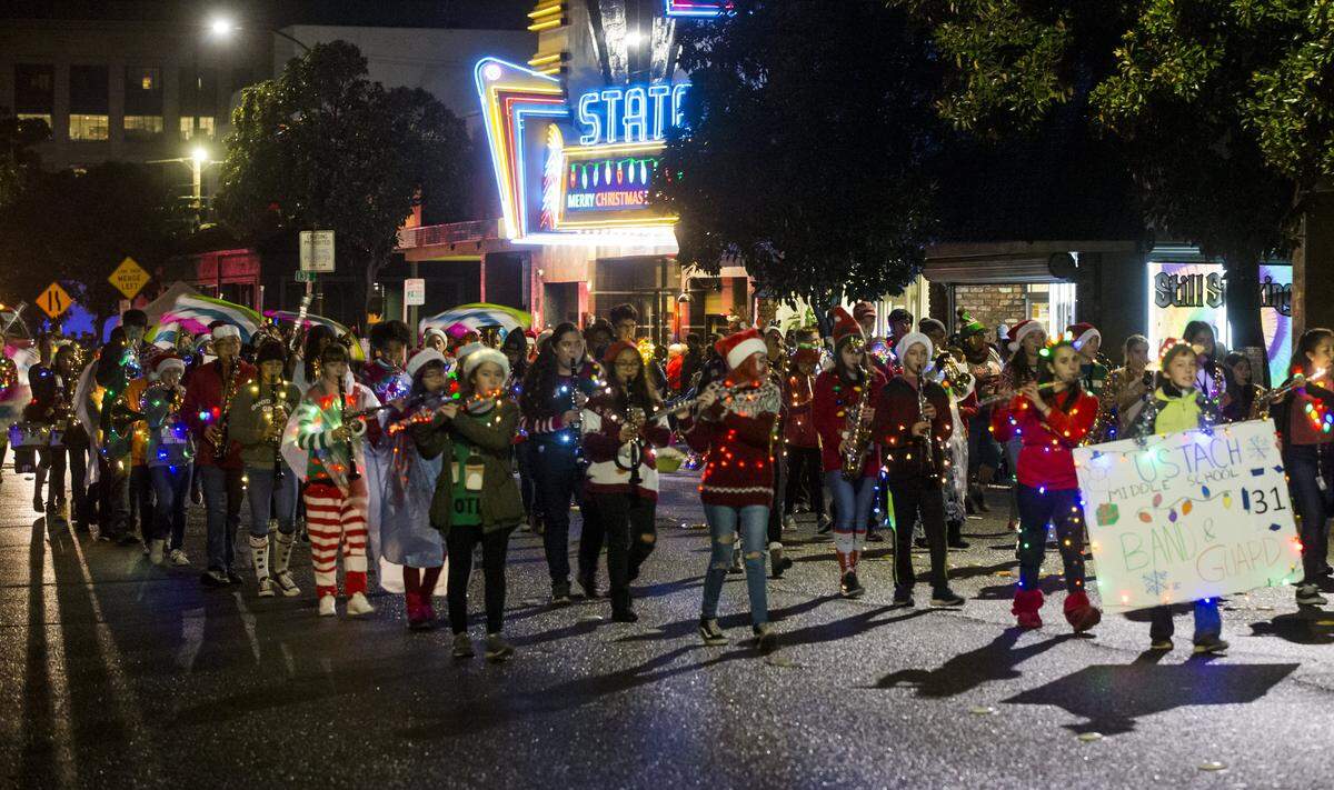 Ustach Middle School marching band and guard walk the parade route during the Celebration of Lights Saturday, Dec. 1, 2018. 