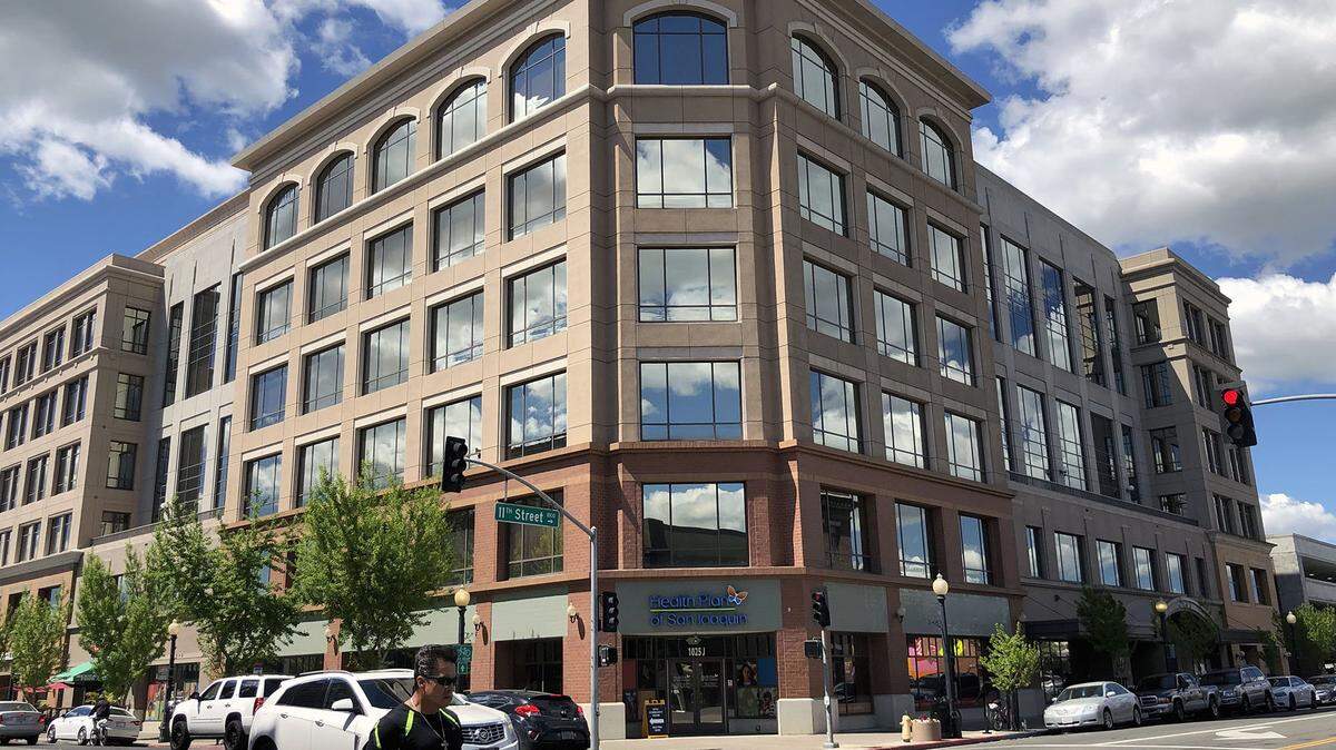 Clouds are reflected in the glass windows at Tenth Street Place, the city/county building in downtown Modesto, Calif. on April 9, 2019.