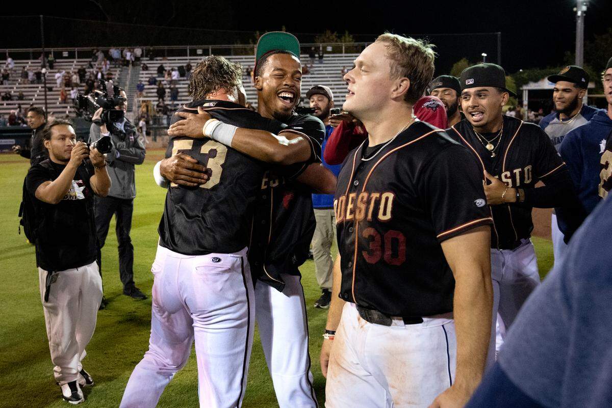 Curtis Washington Jr. and Jack White celebrate the California League Championship title victory over Lake Elsinore with their teammates at John Thurman Field in Modesto, Calif., Wednesday, Sept. 18, 2024.
