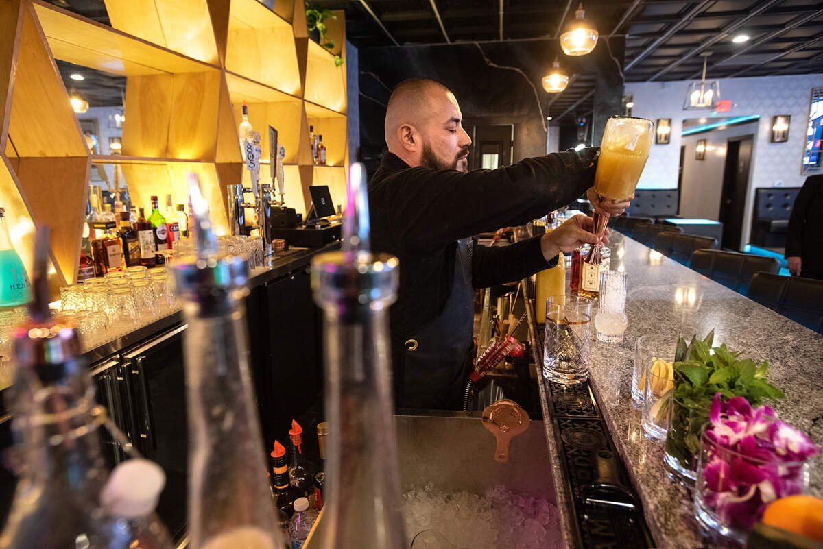 Bartender Noah Tamez makes a Mai Tai cocktail at Spotlight Ultra Lounge in downtown Modesto, Calif., on March 10, 2022. The nightclub is planning to open this month.