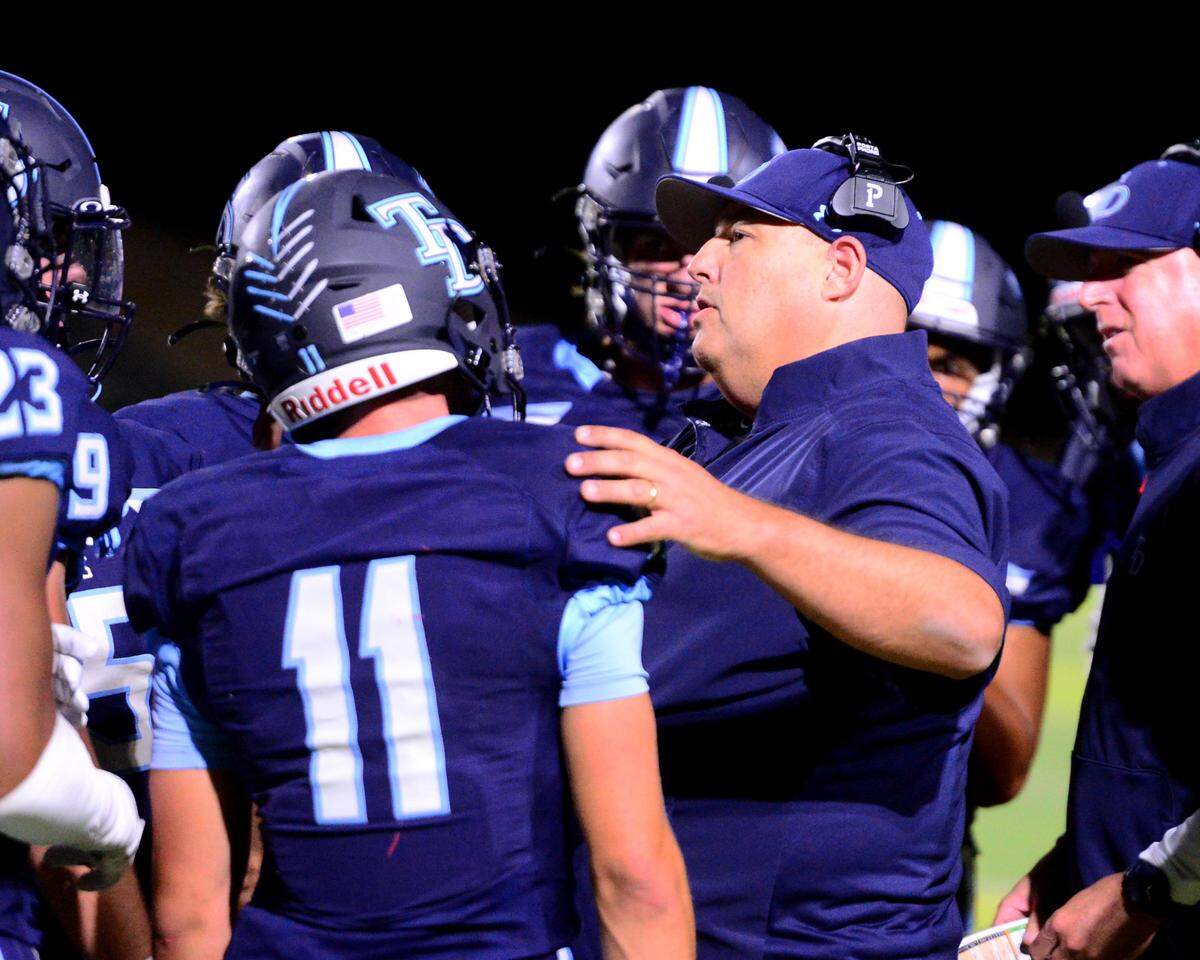 Downey Head Coach Jeremy Plaa talks with his players on a timeout during a game between Downey High School and Merced High School at Downey High School in Modesto California on September 1, 2023.