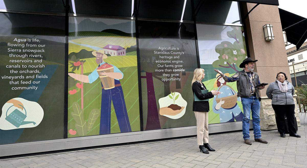 MID board President Robert Frobose speaks with Modesto Chamber of Commerce CEO Trish Christensen and Stanislaus County Farm Bureau Foundation board member Deanna van Klaveren during a formal presentation of a mural honoring the local agriculture industry at Vintage Faire Mall in Modesto, Tuesday, Nov. 25, 2025. 