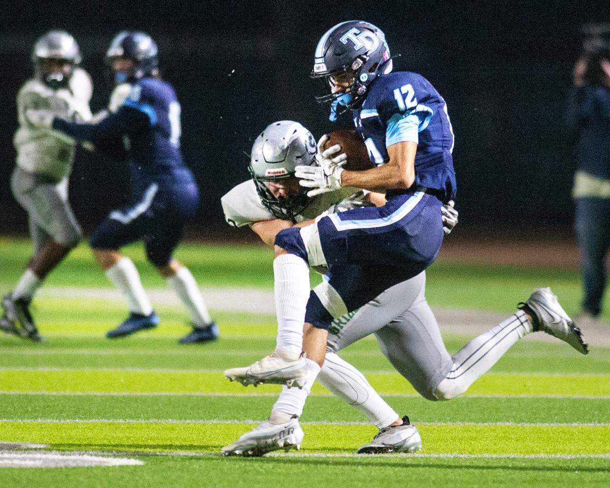 Downey receiver Gabe Hernandez is stopped by Granite Bay’s Dj Khatami the CIF Sac-Joaquin Section Division II playoff game at Downey High School in Modesto, Calif., Friday, Nov.11, 2022.