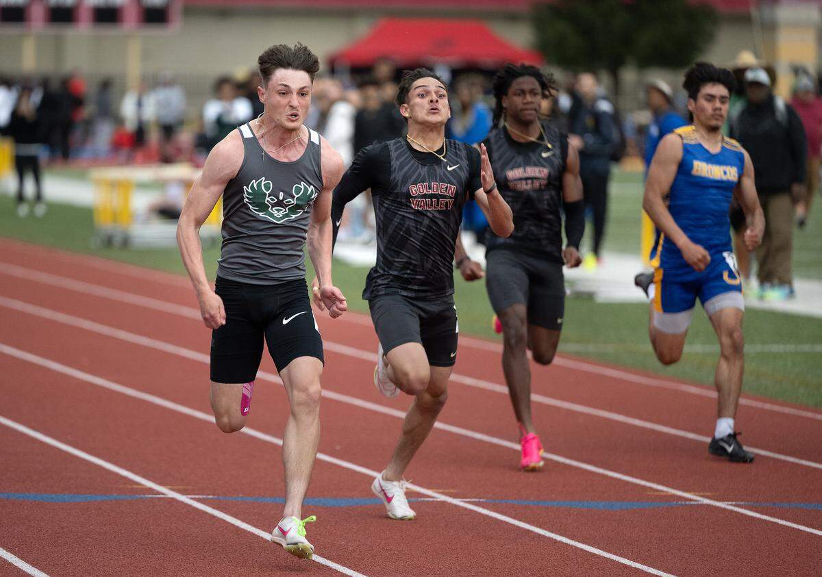Pitman’s Blayne Siebert, left, won the 100 meter race with a time of 10.75 and Carlos Miranda Esquivel of Golden Valley placed second at 10.93 during the County Clash track meet at Oakdale High School in Oakdale, Calif., Friday, March 22, 2024.