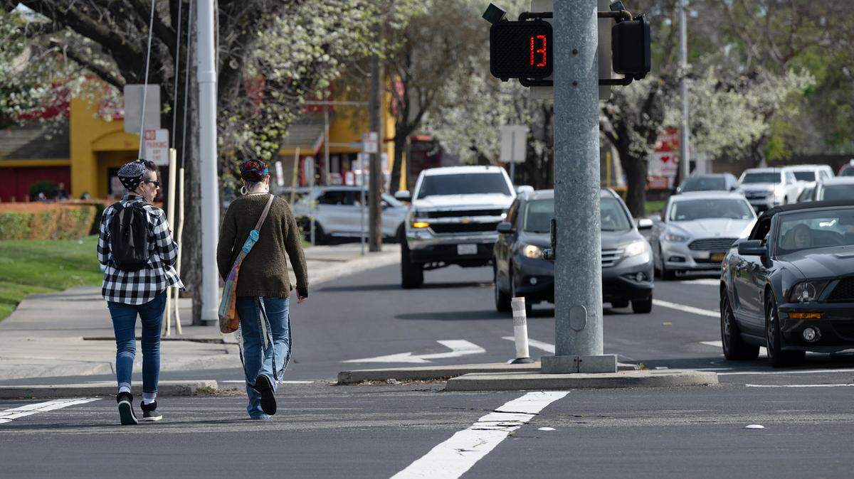 Pedestrians cross Standiford Avenue in Modesto, Calif., Saturday, March 9, 2024. 