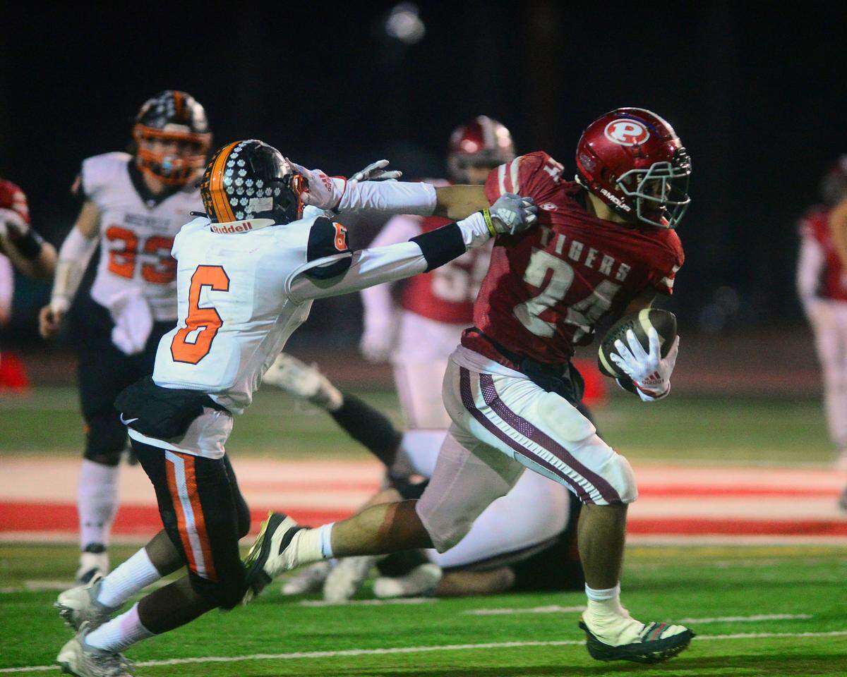 Patterson running back Lolo Mataele stiff-arms a defender during a CIF Division III Sac-Joaquin Section football playoff game against Roseville at Patterson High School in Patterson, California, on Nov. 11, 2022. Patterson won 56-34.