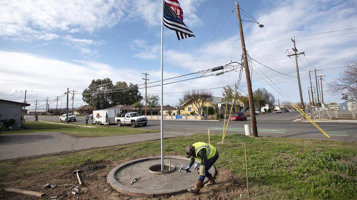 Sergio Ramos works on the foundation of a flagpole near where police Cpl. Ronil Singh was fatally shot Dec. 26, 2018, while conducting a traffic stop. The pole was dedicated during a vigil on the year anniversary of his death. Photographed in Newman, Calif., on Wednesday, Dec. 18, 2019.