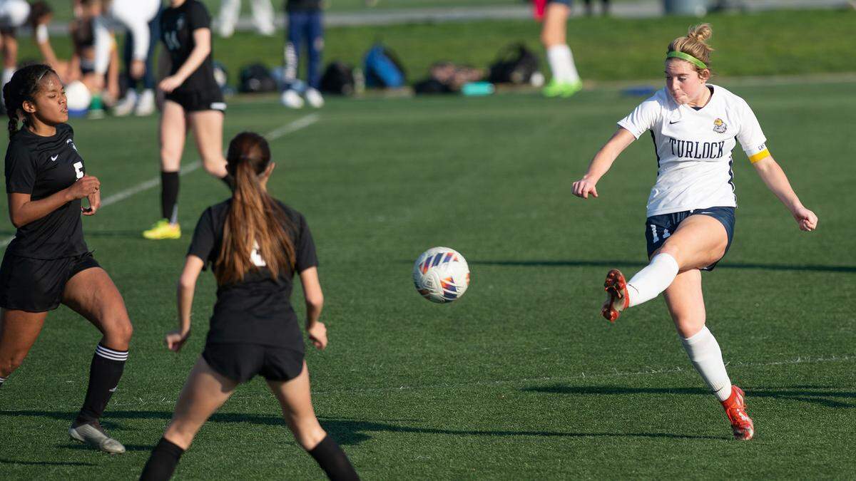 Turlock’s Jenna Dean passes the ball past Enochs defenders during a Central California Athletic League game with Enochs at Mary Grogan Community Park in Modesto, Calif., Wednesday, Jan. 25, 2023. Turlock won the game 1-0.