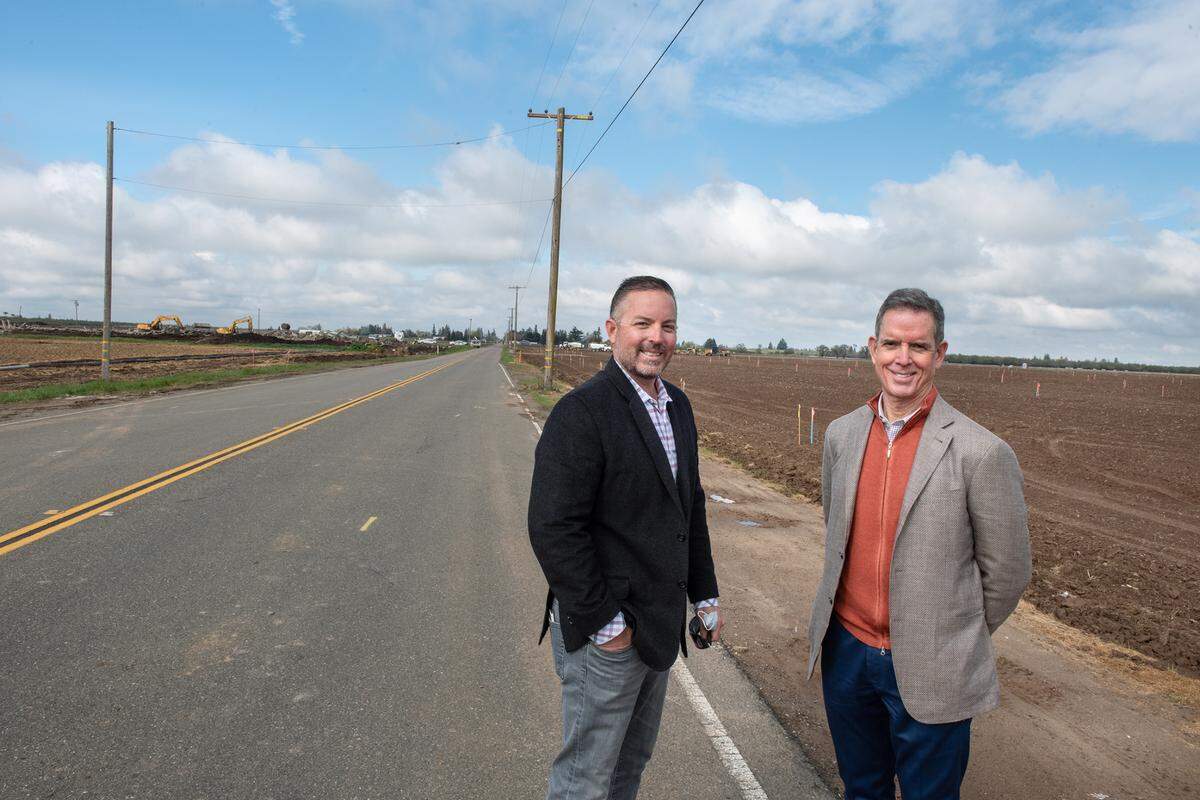 Randy High Jr., whose family owns most of the land, and builder Tom Doucette, president of FCB Homes, right, stand on Crawford Road as preparation for construction has begun on Crossroads West, a new housing development in Riverbank, Calif., on Thursday, March 11, 2021.