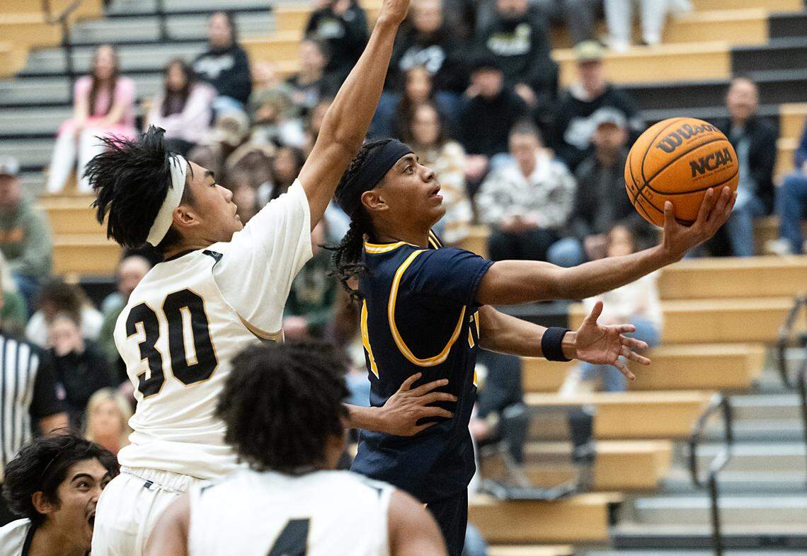 Turlock’s Ross Widemon scores on a layup past Enochs’ Roshaun Belleza during the Central California Athletic League game at Enochs High School in Modesto, Wednesday, Jan. 15, 2025. Enochs won the game 66-63.