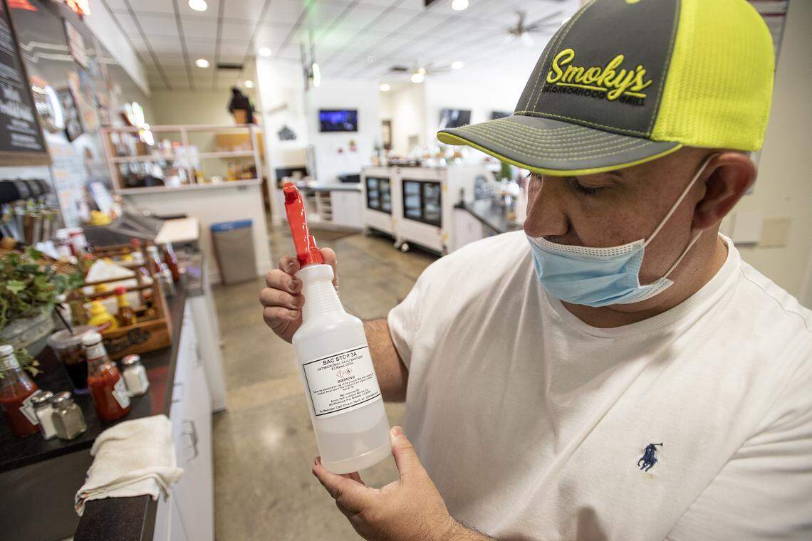 Owner Mike Nelson says his employees will use sanitizer to maintain stricter cleaning standards at Smoky’s Neighborhood Grill in Modesto, Calif., on Wednesday, May 20, 2020.