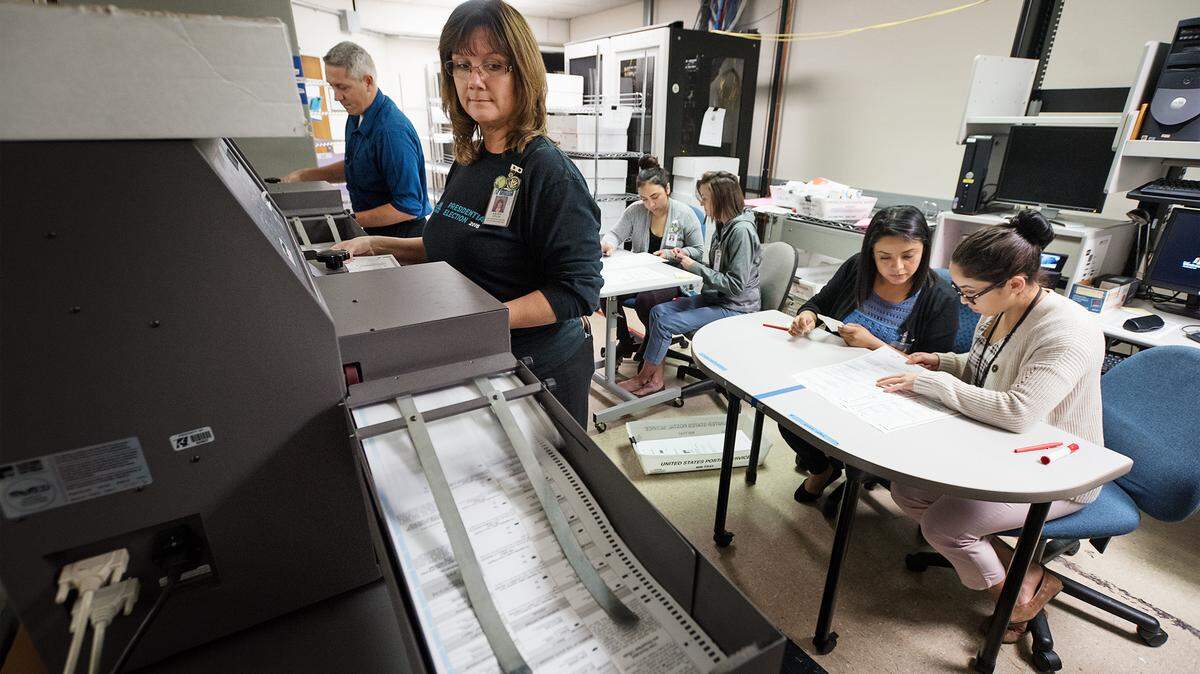Kathy Styles feeds ballots into the tabulation machine at the Stanislaus County Clerk Recorders office in Modesto, Calif., Thursday, Nov. 1, 2018.