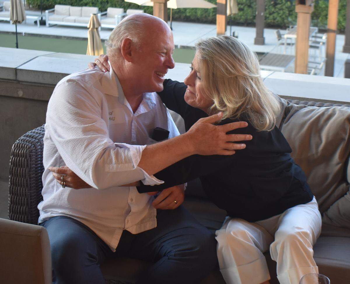 Kim Davis reaches over to embrace her husband, Bruce, at their Beyer High School Class of 1975 reunion at Del Rio Country Club north of Modesto on Saturday, Sept. 13, 2025.
