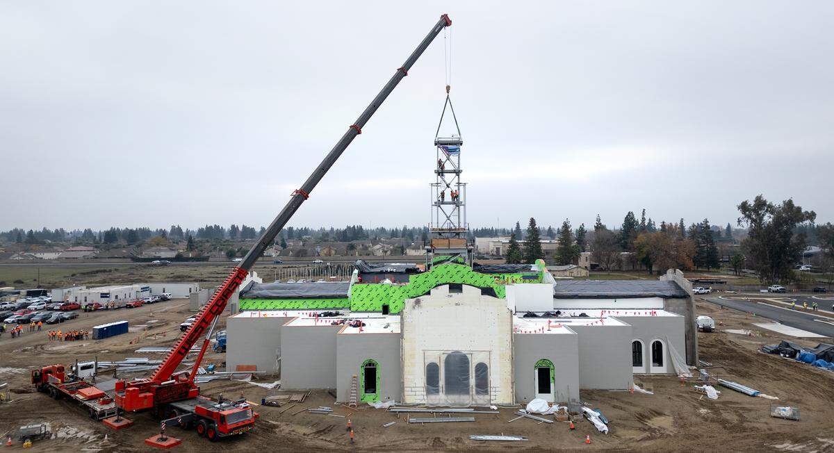 A crew secures the final section of the tower in place at the Church of Jesus Christ of Latter-day Saints new temple on Dale Road in Modesto, Thursday, Dec. 19, 2024.