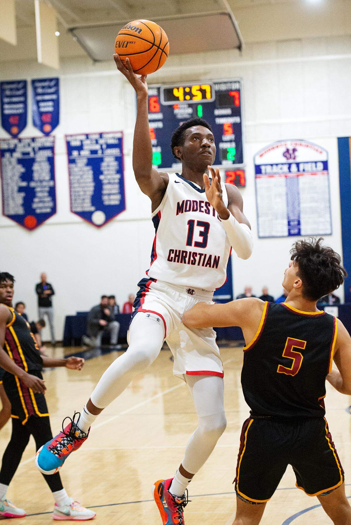 Modesto Christian’s Prince Oseya scores over Clovis player Tytus Khajavi during the Modesto Christian Holiday Hoop Classic championship game at Modesto Christian High School in Salida, Calif., Friday, Dec. 30, 2022.
