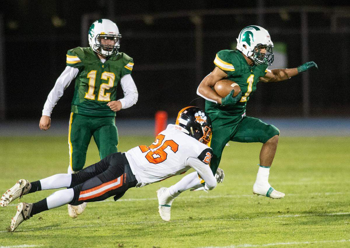 Roseville’s Jaden Keirsey wraps up Davis runner Isaac Martinez in the Division III Sac-Joaquin Section football playoff game at Modesto Junior College, in Modesto Calif., on Friday, Nov. 5, 2021. Roseville won the game 33-21.