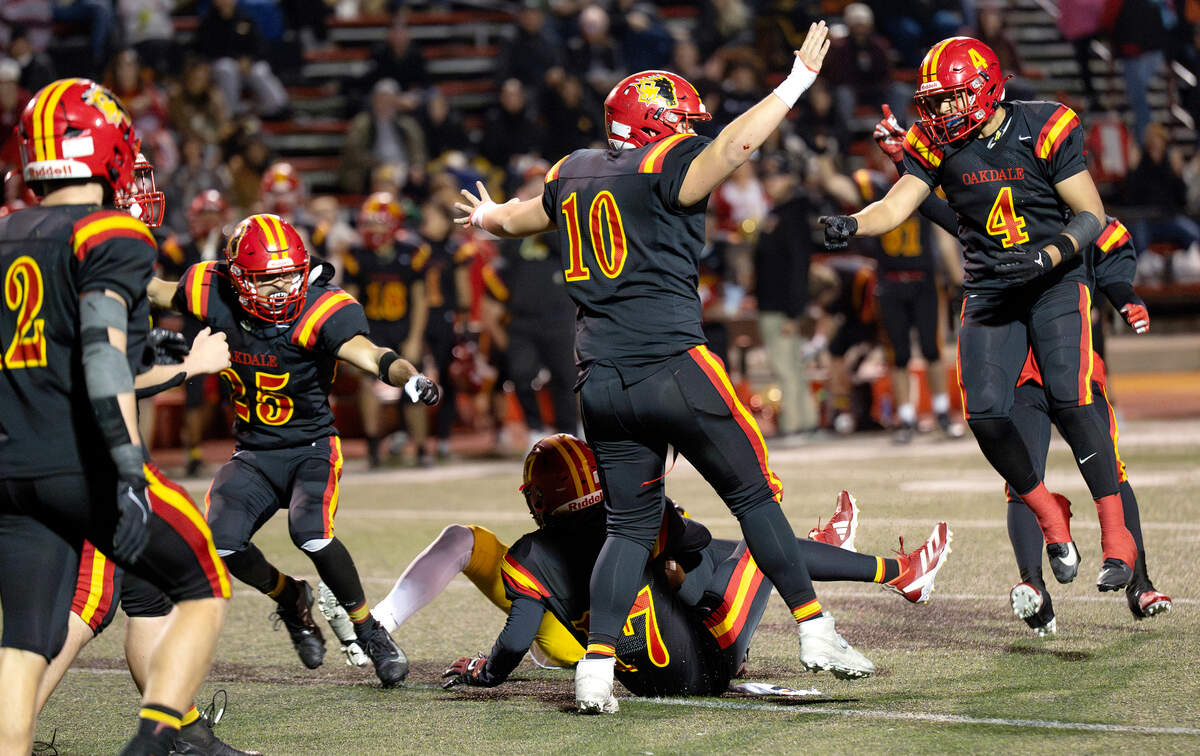 Oakdale players celebrate an interception by teammate Peyton Wallace (17) during the Sac-Joaquin Section Division III semifinal game with Vanden at Oakdale High School in Oakdale, Friday, Nov. 21, 2025.