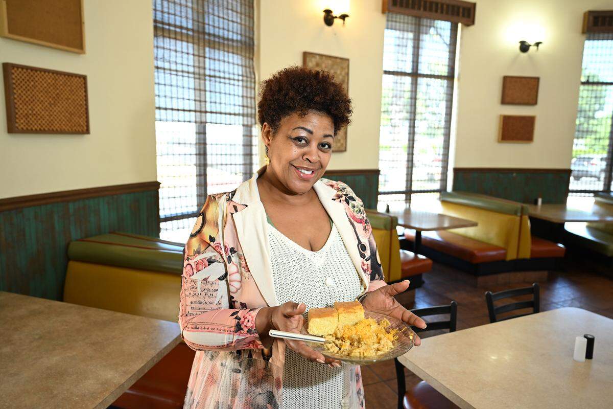 Owner and chef Muriel Askew holds a dish of macaroni & cheese with cornbread at Muriel’s Southern Comfort Food in Patterson, Tuesday, May 19, 2026.