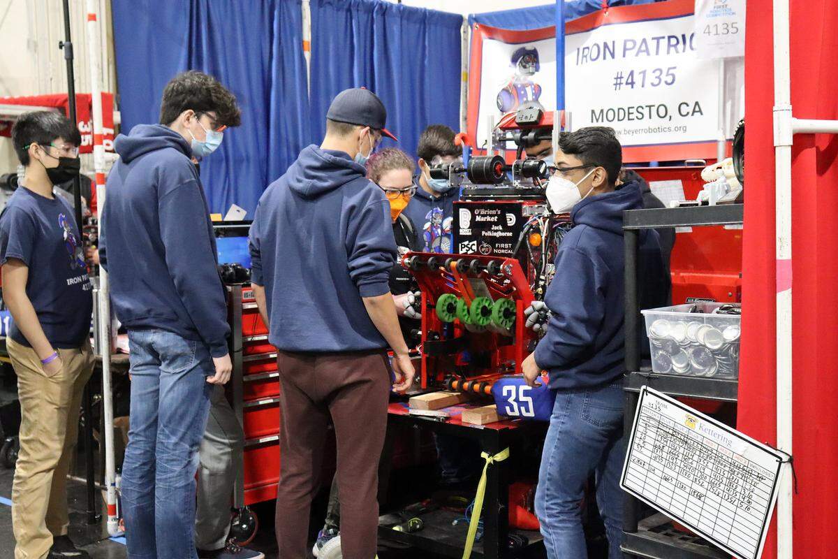 Iron Patriot members Evan Hardy, Hudson Monday, Adrian Fuentes and Matthew Davis work with a student from a different team to solve a problem at a regional robotics competition March 23-26 in Monterey Bay.