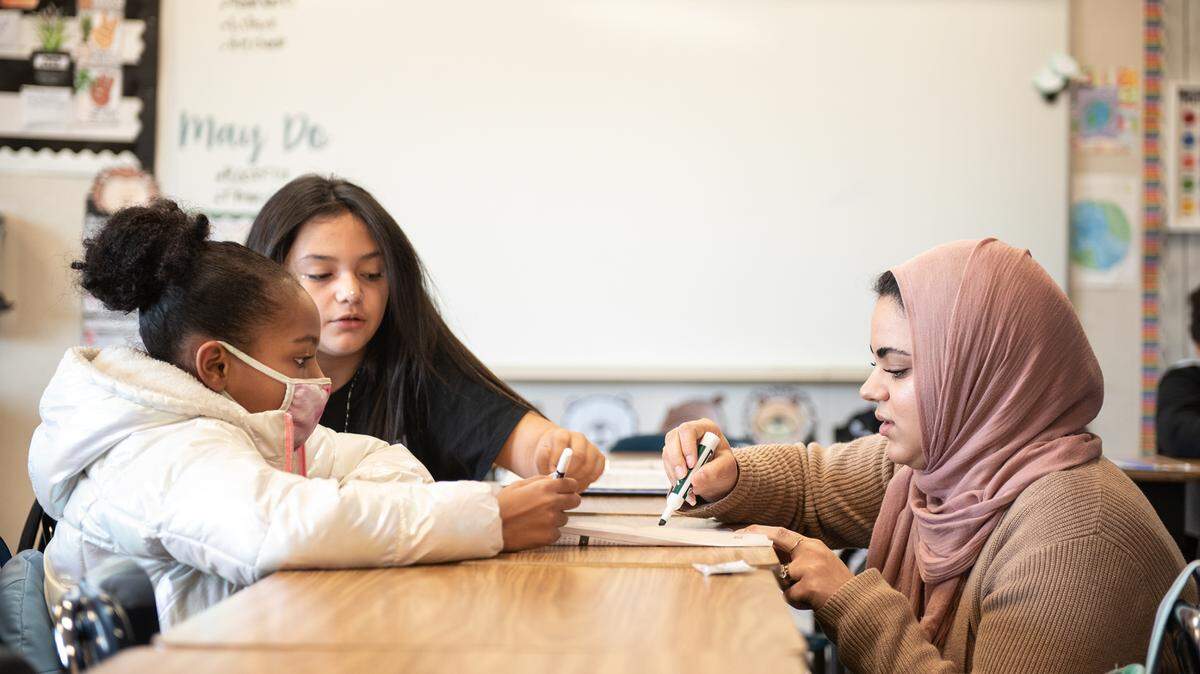Fourth grade teacher Heba Morad works with Juanita Curry, left, on a self assessment worksheet after a math assignment at Walter White Elementary School in Ceres, Calif., Wednesday, Dec. 14, 2022.