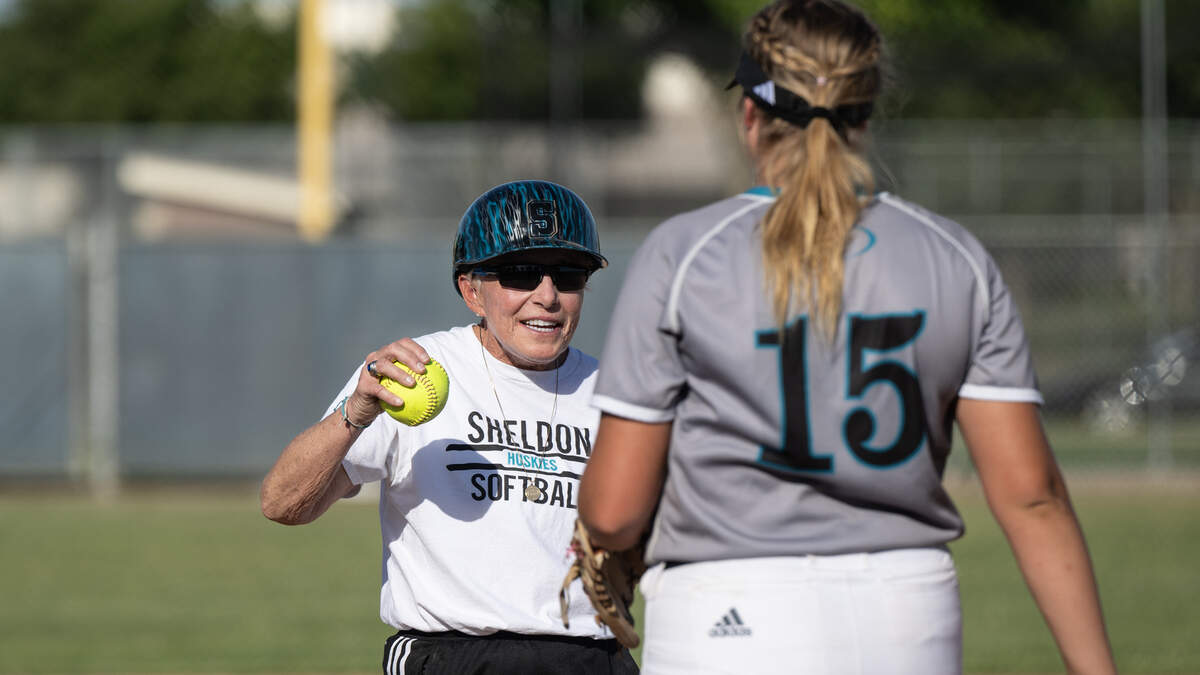 Sheldon head coach Mary Jo Truesdale hands the ball off to pitcher Kwinci Brown in the Sac-Joaquin Division I playoff game May 16, 2023, at Gregori High School in Salida.