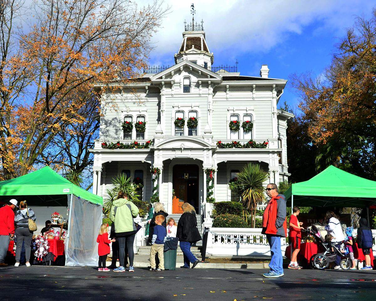 Visitors walk past the McHenry Mansion during the Dickens Faire in Downtown Modesto on December 1, 2018. It will be dressed up very differently this Halloween season.