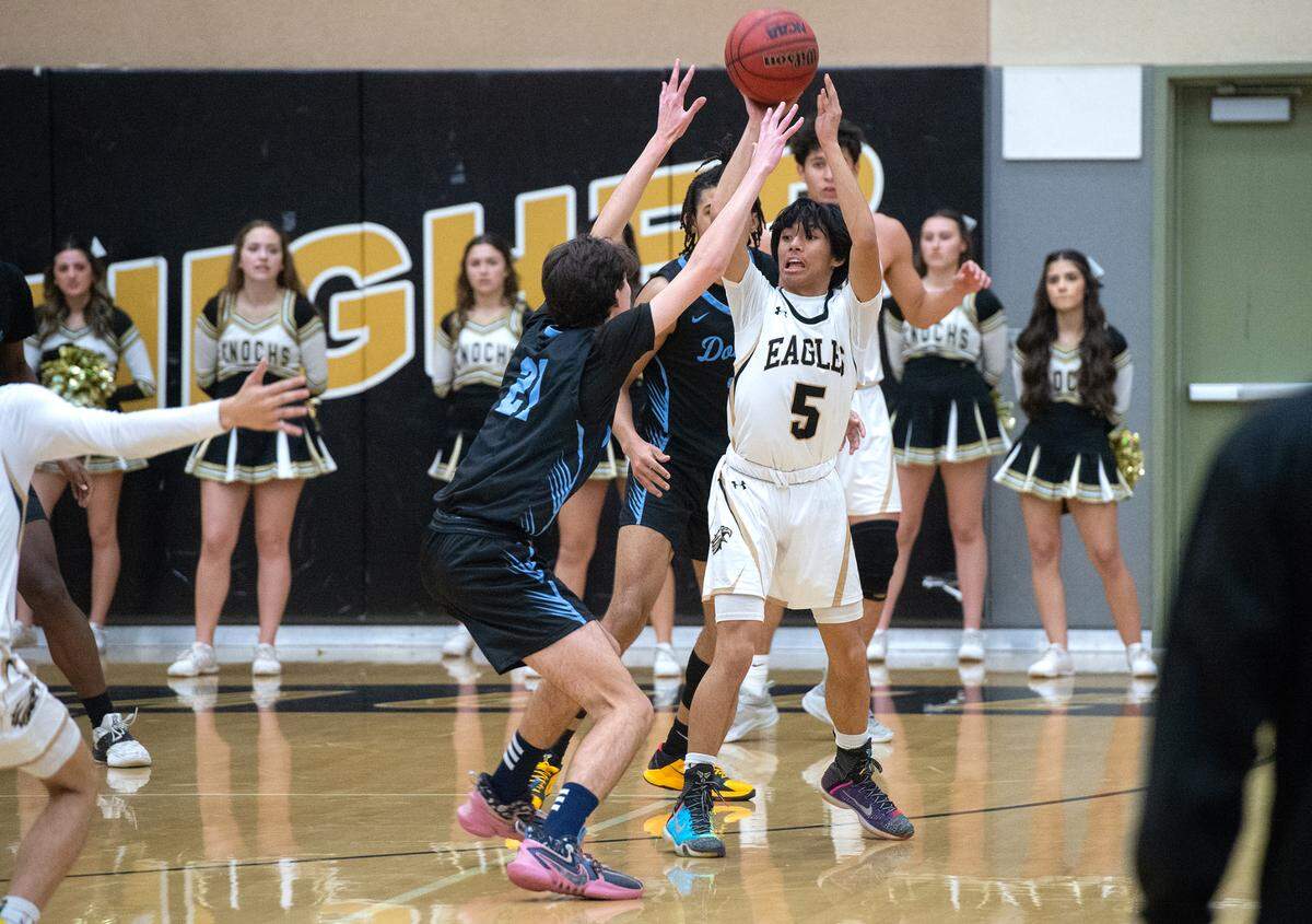 Enochs’ Trent Acedillo (5) looks to pass under pressure from Downey’s Collin Eden during the Central California Athletic League game at Enochs High School in Modesto, Calif., Friday, Jan. 27, 2023.