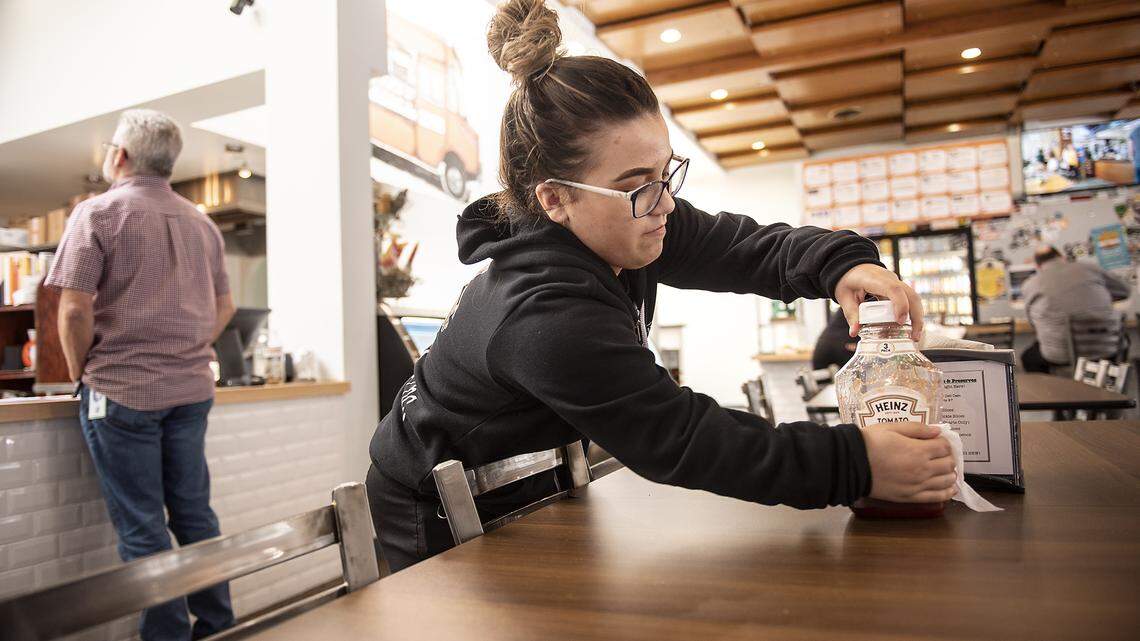 Nathalie Castillo cleans condiments, chairs, and other things at Food Fix Butcher & Baker restaurant in Modesto, Calif., on Friday, March. 13, 2020.