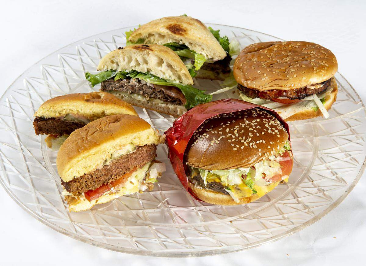 Meatless burgers photographed in The Modesto Bee studio in Modesto, Calif., Friday, April 19, 2019. Clockwise from the front, Red Robin’s Impossible burger, Black Bear Diner’s Beyond Meat burger, Diva Cafe Impossible burger, and Carl’s Jr. Beyond Meat burger.