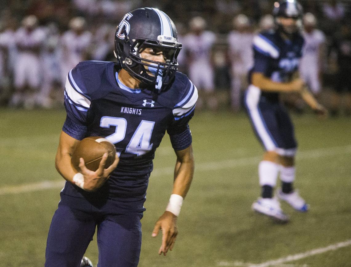 Jordan Wilson, 24, looks up the sideline and to gain yardage. Downey High took on East Union Friday Aug. 17, 2018.